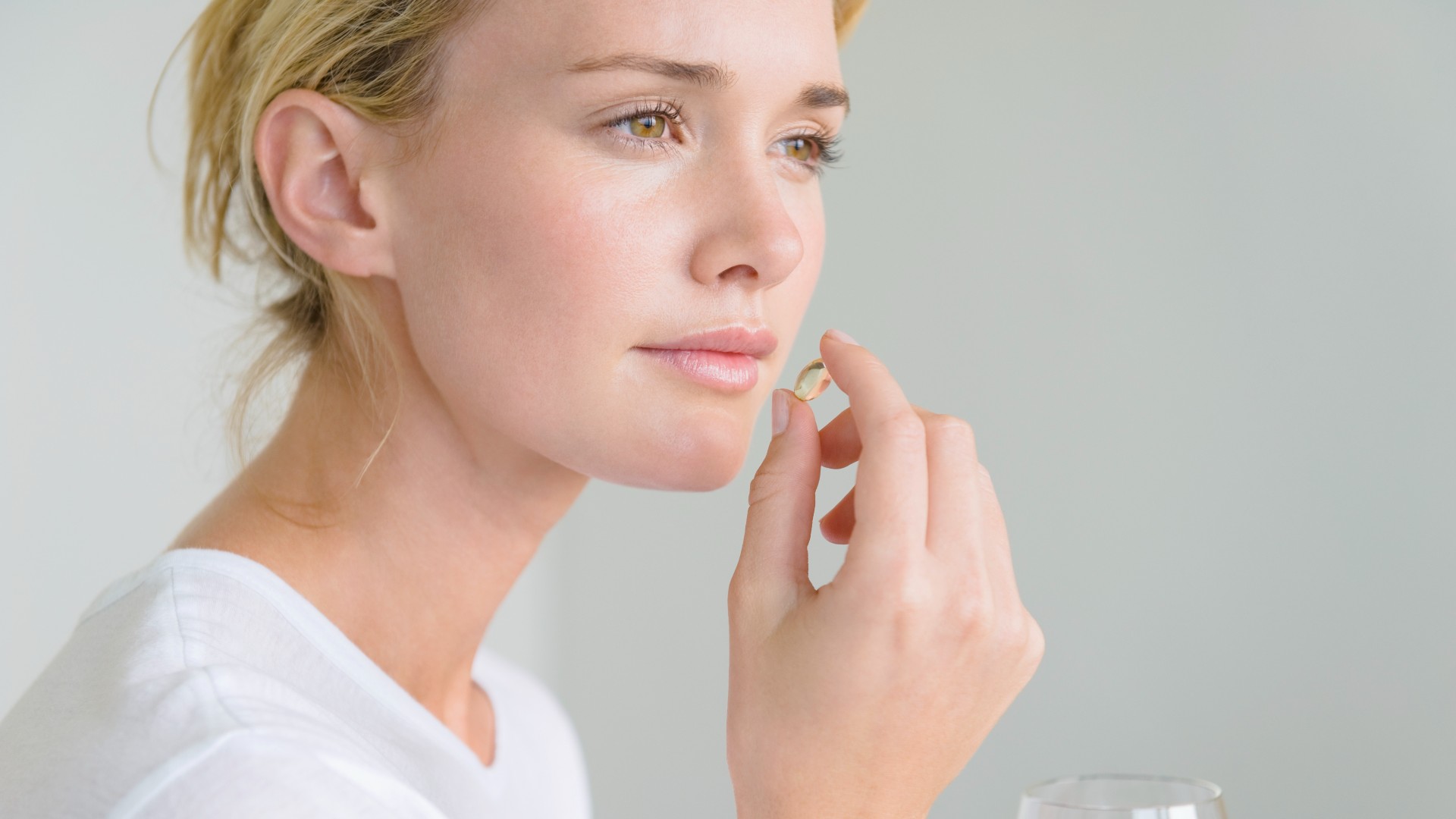 A woman taking a fish oil tablet