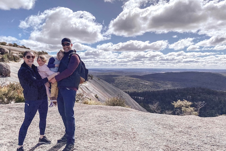 A woman, a man and their two children on top of a mountain