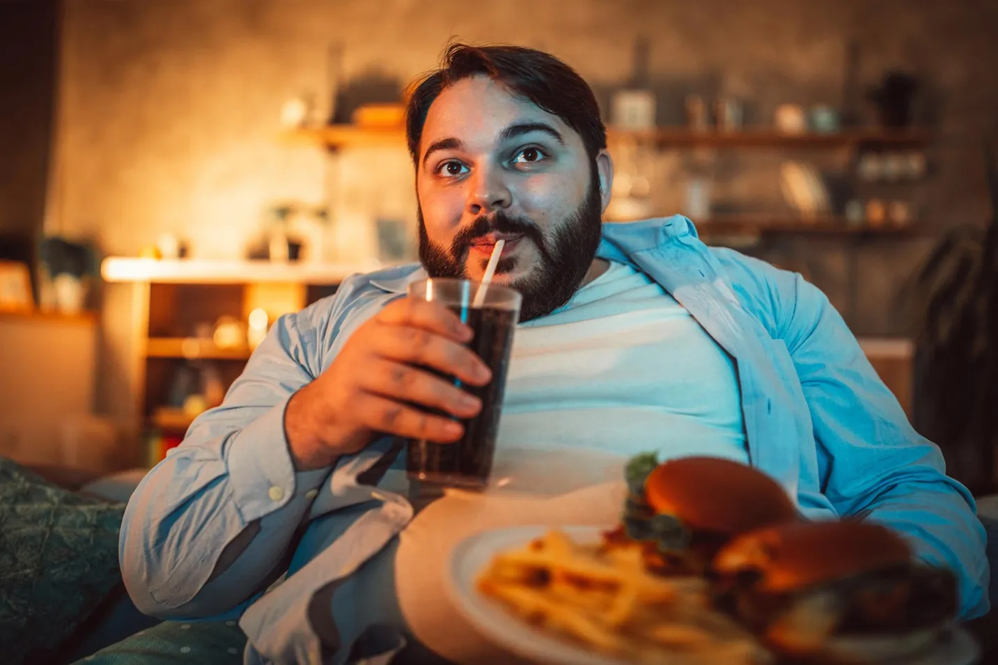 The fat man eats fast food