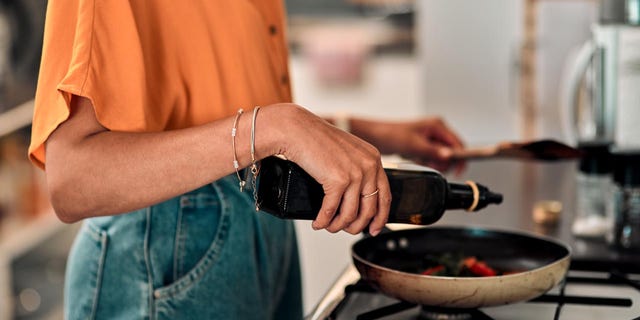 Young woman preparing a healthy meal at home. Students began asking Dr. Hauser how they could eat differently to improve their health.