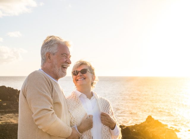 Happy senior couple positive vibes on the beach